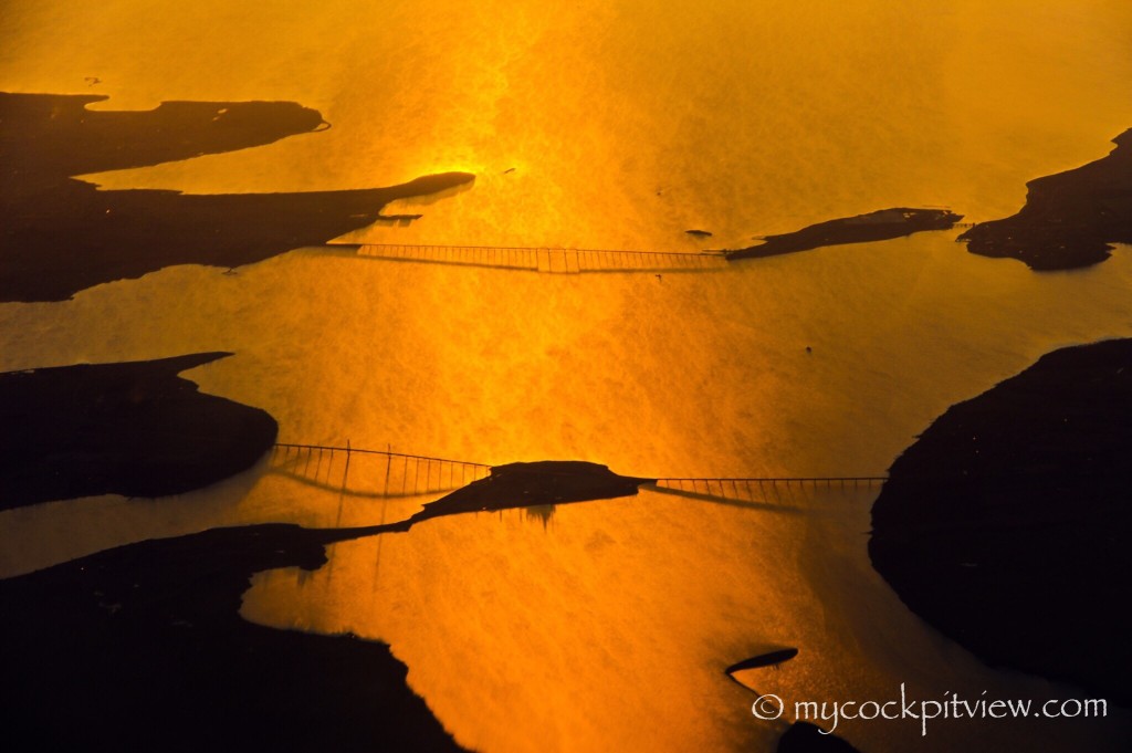 Mycockpitview. Descending towards Copenhagen, bridges over water turned into gold due to the sunset.